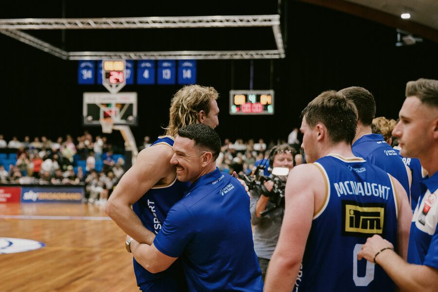 Jamie O'Donnell celebrating with Nelson Giants basketball players